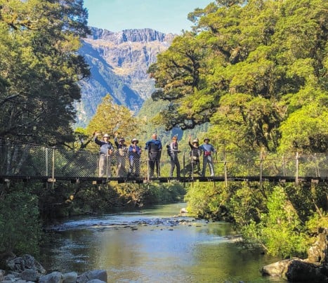 0 Group of guests waving from bridge milford track GW