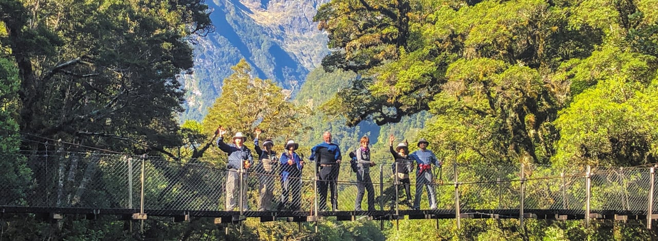 Header guests waving from bridge milford track2