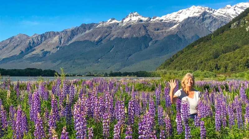 Solo women waving lupins lake tekapo blog nov26