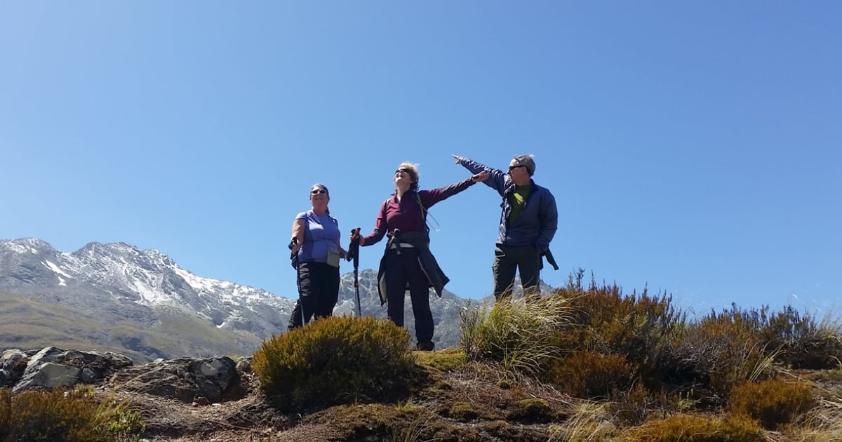 Woman hikers climbs a mountain on the grass track. Hiking