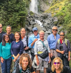 Group at Devils Punchbowl Waterfall at Arthurs Pass River, Canterbury New Zealand