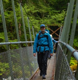Hiking over bridge Hollyford River