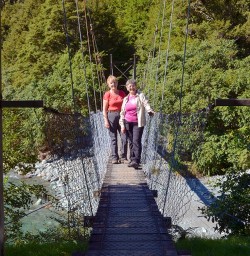 hikers crossing swingbridge on the hollyford track