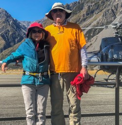 Couple with helicopter at Aoraki Mount Cook National Park, Canterbury New Zealand