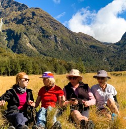 1. Guests sitting in grass Routeburn Track