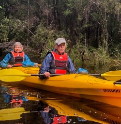 Couple kayaking at Okarito Lagoon, West Coast New Zealand
