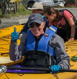 Guest ready to kayak at Okarito Lagoon, West Coast New Zealand
