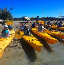 The team excited for their kayaking trip on the Okarito Lagoon