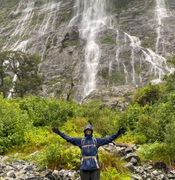 3. Solo guest infront of waterfalls in Milford Sound