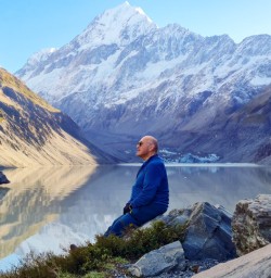 Solo guest sitting at Hooker Lake Mt Cook