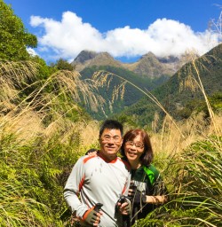 5. Happy guest couple Hollyford Track big mountain back drop