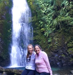5. Two happy guests next to waterfall on Hollyford Track
