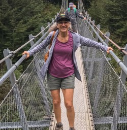Guest on the bridge at Routeburn track river, Otago New Zealand