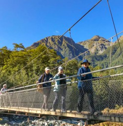 Guests hiking on Routeburn swing bridge