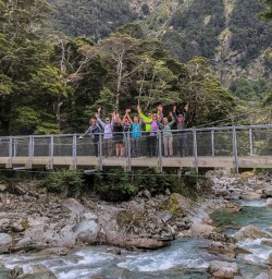 Group on the bridge at routeburn track river, Otago New Zealand