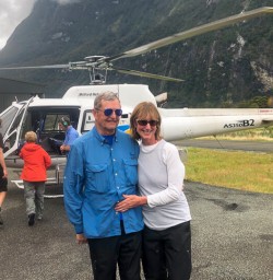 Couple with helicopter at Milford sound, Fiordland New Zealand