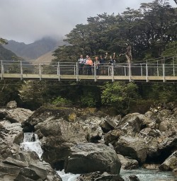 Group on the bridge at routeburn track river, Otago New Zealand