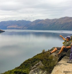 9. Guide and guests sitting on cliff top lookout over Lake Wanaka