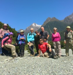 Walking group under blue skies on the Hollyford Track