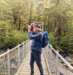 1. Guest taking photo on bridge Routeburn Track