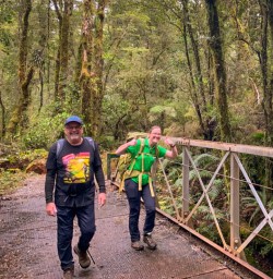 Happy guide and guest on bridge Milford Track