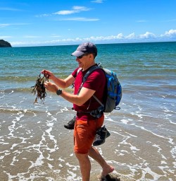 male guest exploring the beach at the Rakiura Track